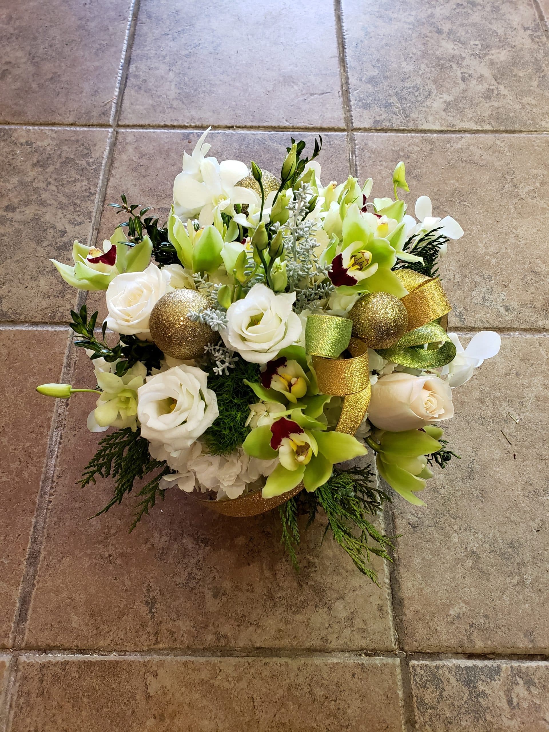 Under the Mistletoe holiday arrangement with red roses and cedar