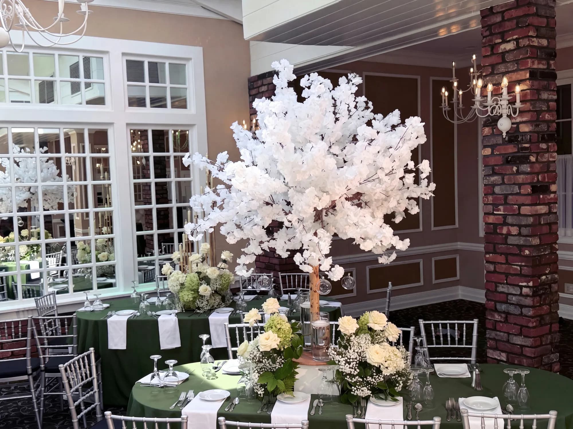 White blossom-tree centerpiece over green linen