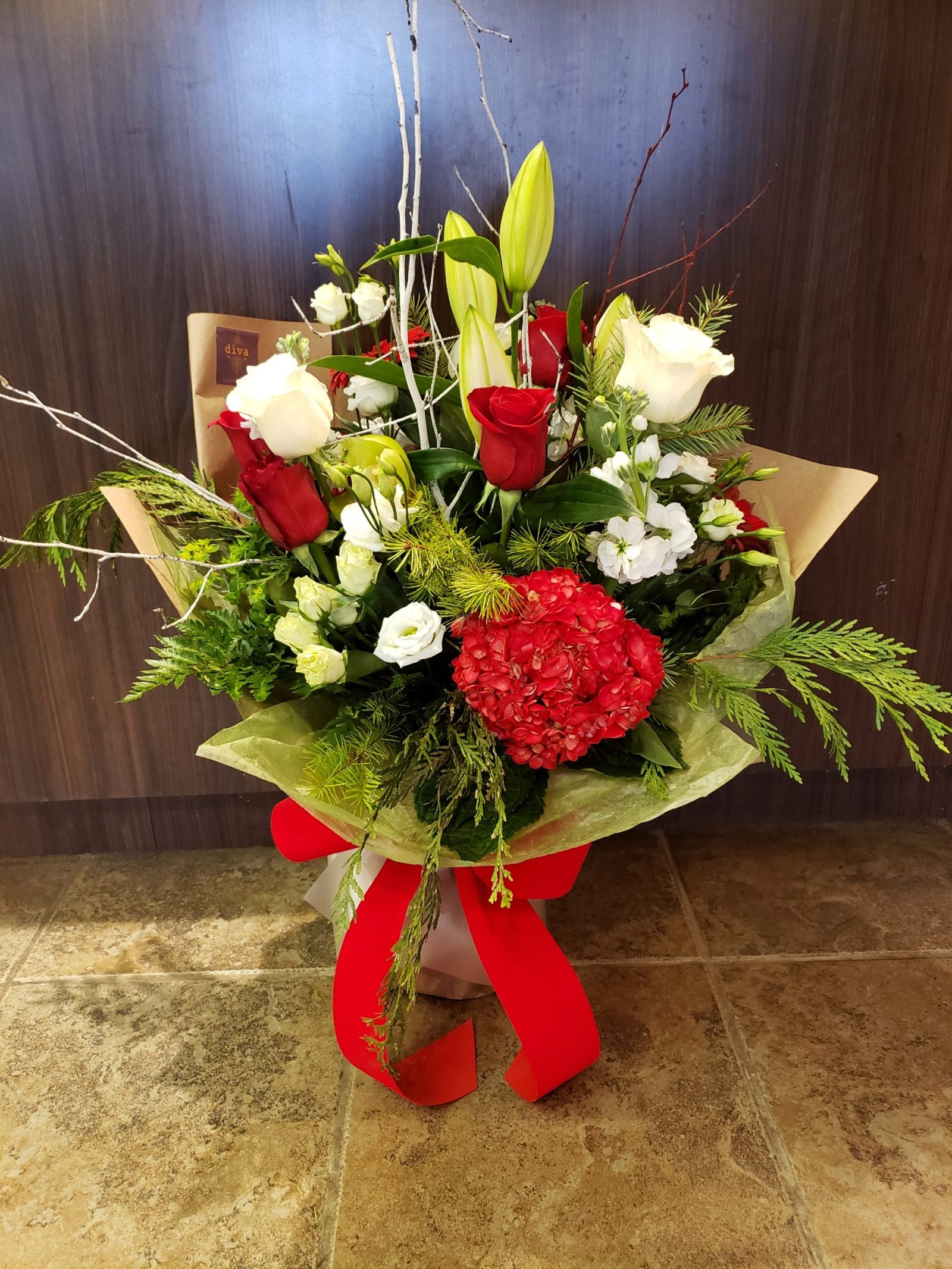 Santa's Garden Christmas arrangement with red roses and amaryllis