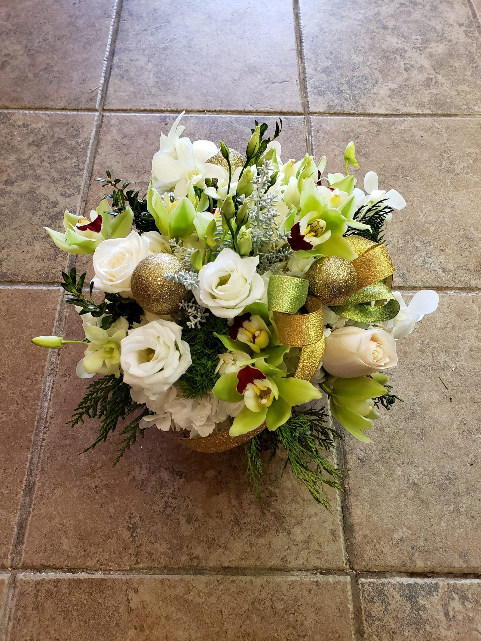 Under the Mistletoe holiday arrangement with red roses and cedar