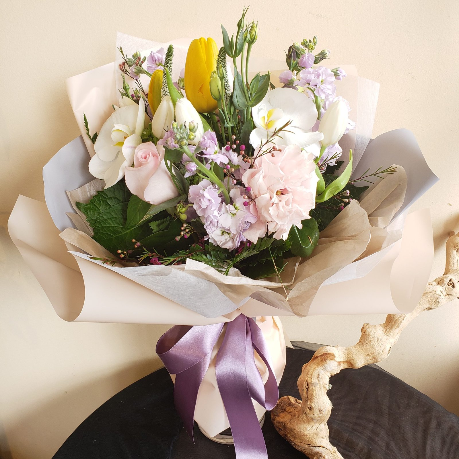 Small bouquet of yellow and cream flowers tied with natural cord